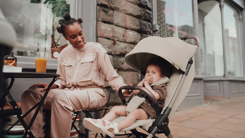 Woman sitting with a child in a stroller on a patio